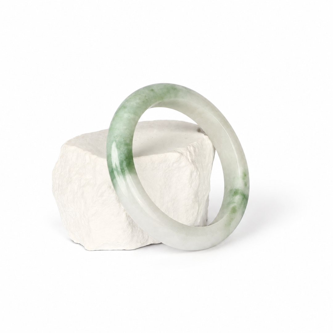 White and light green Jadeite bangle, hero view on white stone